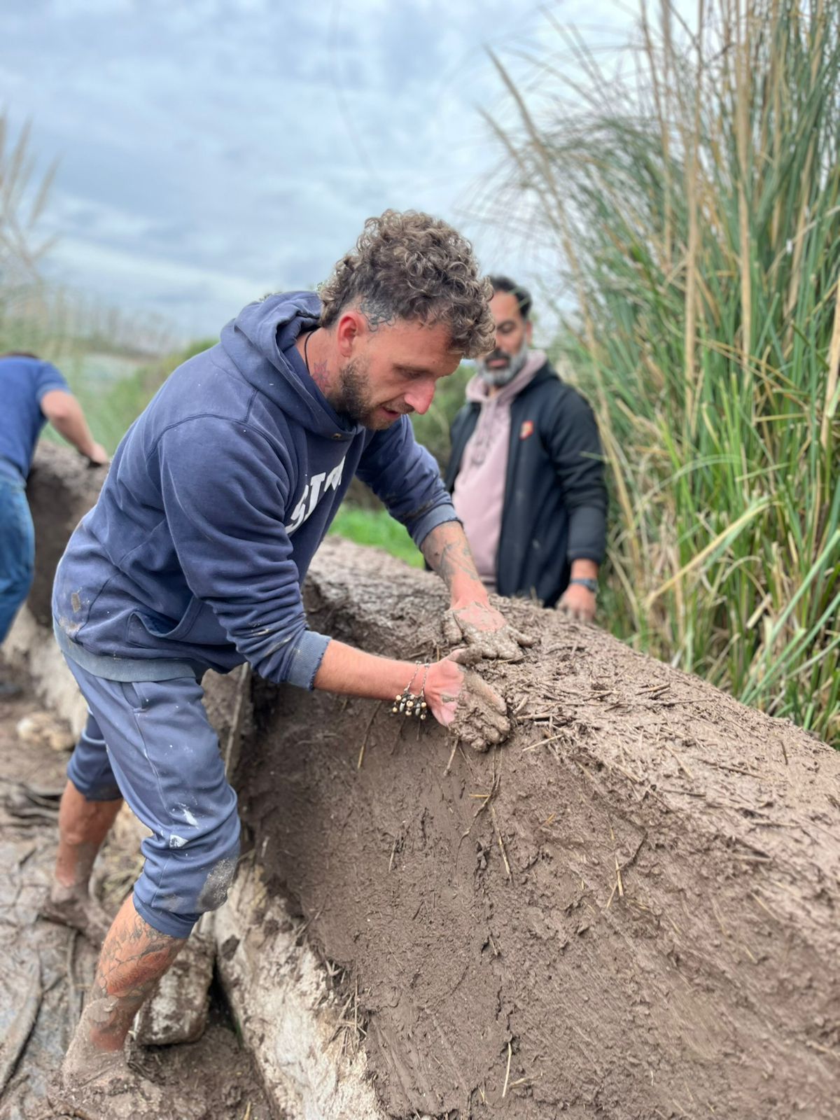 Cristian Sampirisi construyendo con barro en obra de bioconstrucción